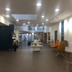 L'acceuil de la bibliothèque départementale de la Sarthe donne sur tous les espaces dont est constituée la bibliothèque. Y apparaissent des expositions, des assises et une banque d'acceuil.