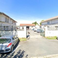 Vue depuis l'avenue de Verdun sur les anciens abattoirs de Marans. L'entrée, les deux bâtiments et le portail.